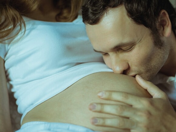 papa embrasse le ventre de la maman enceinte