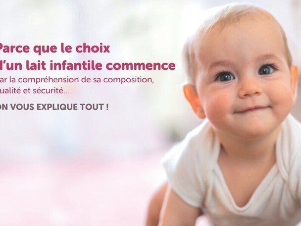 Bébé rampant dans une tenue blanche, fond flou.