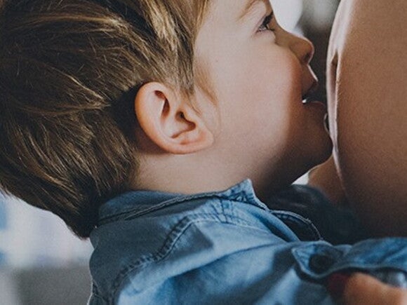 Toddler kisses mommy's baby