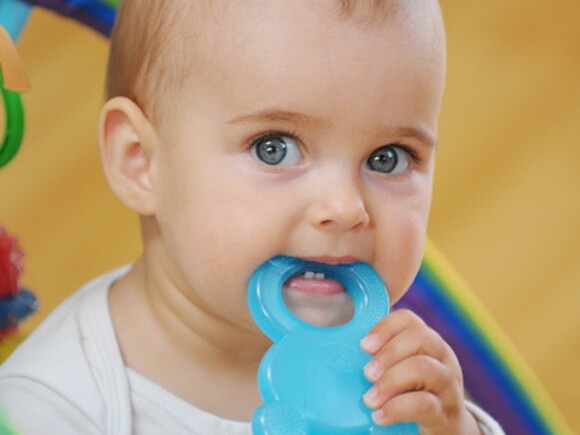 bebe avec jouet dans la bouche