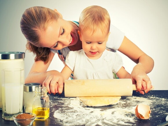 maman aide bébé à utiliser un rouleau à pâtisserie