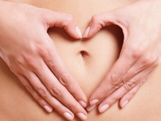 Ventre de femme avec mains en forme de cœur