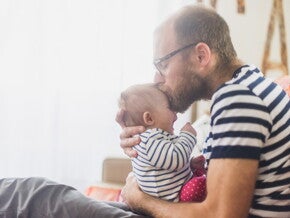 Papa qui embrasse son bébé sur le front