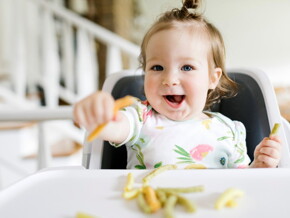 Bébé qui mange des légumes avec les mains