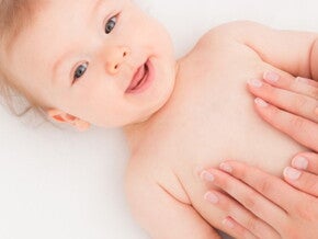 bébé allongé avec mains de mamans sur le ventre