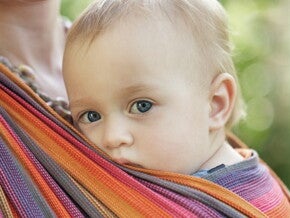 un bébé porté par maman