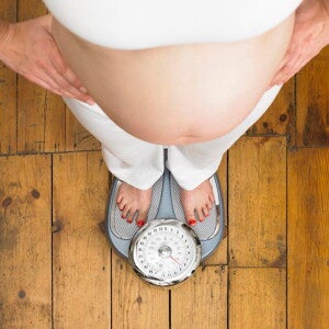 Femme enceinte qui prends son poids sur une balance