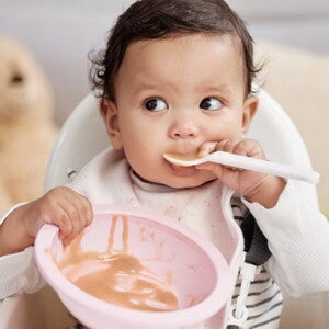 Bébé qui mange avec une cuillère