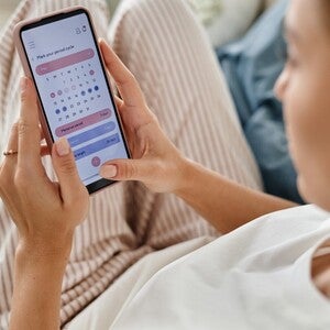 Person using a period tracking app to monitor menstrual cycle dates