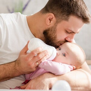 Papa qui donne le biberon de lait à son bébé