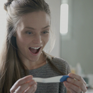Femme enceinte apprenant sa grossesse avec un test de grossesse