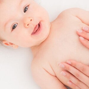 bébé allongé avec mains de mamans sur le ventre bébé allongé avec mains de mamans sur le ventre
