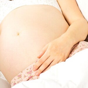 femme enceinte allongee sur le cote une main sur le ventre