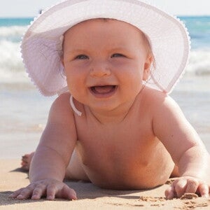 bebe en chapeau sur la plage
