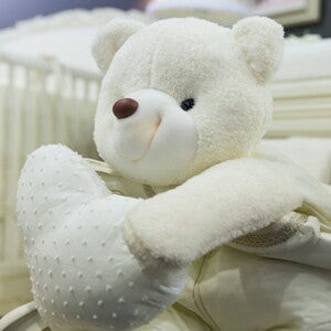 lit de bebe à barreaux avec peluche
