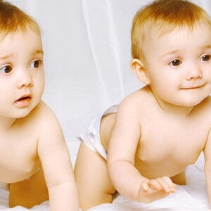 Bébes jumeaux marchent à quatre pattes vers nous et regardent à droite