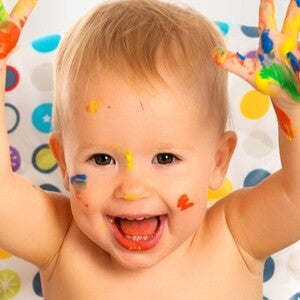 bébé content, les mains avec de la peinture colorée