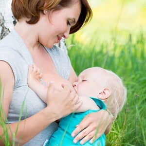 maman allaitant son bebe dans l'herbe