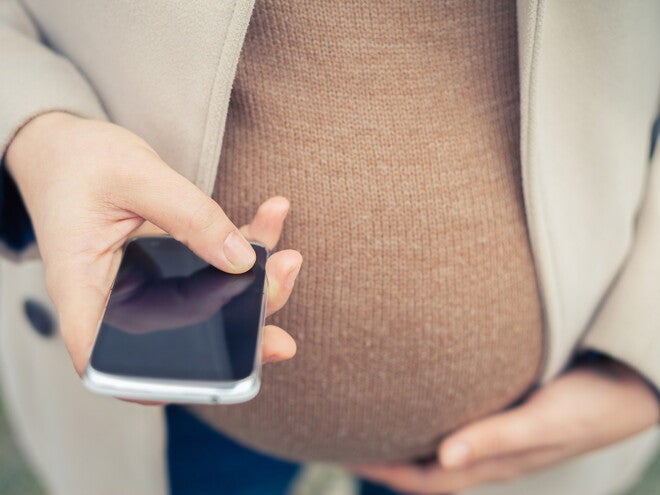 Le 5ème mois de grossesse Femme enceinte utilisant son portable