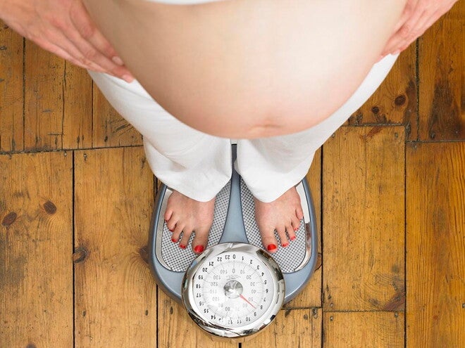 Régime post grossesse Femme enceinte qui prends son poids sur une balance