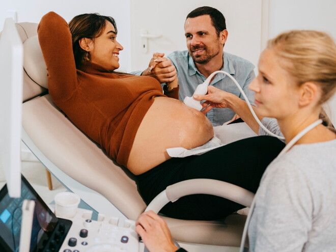 femme tenant une échographie devant son ventre femme tenant une échographie devant son ventre