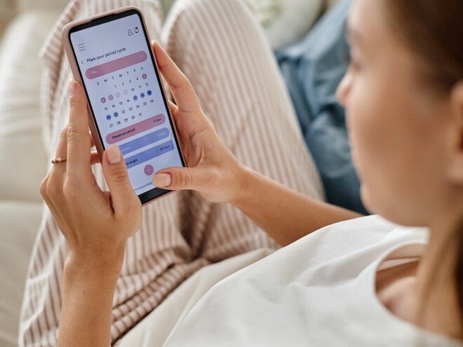Personne utilisant une application de suivi des règles pour suivre les dates de son cycle menstruel