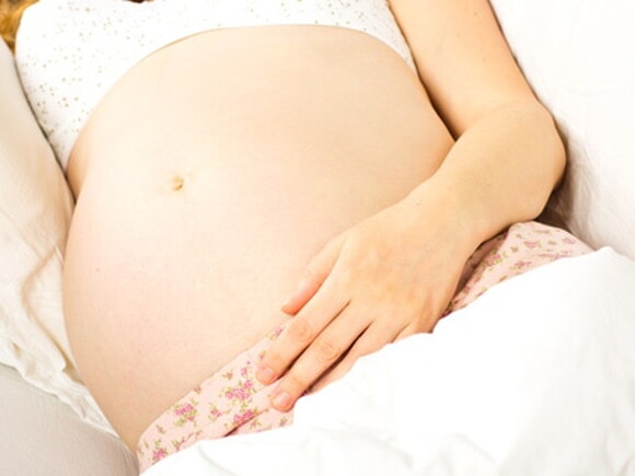 femme enceinte allongee sur le cote une main sur le ventre