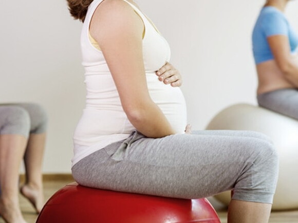 Cours de préparation à l'accouchement : femme enceinte sur ballon de grossesse