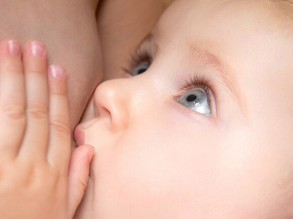 bebe aux yeux bleu tetant le sein de sa maman