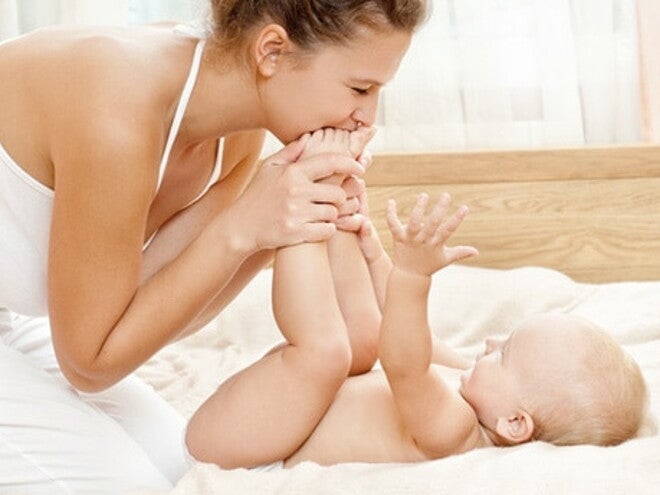 maman qui embrasse les pieds de bébé