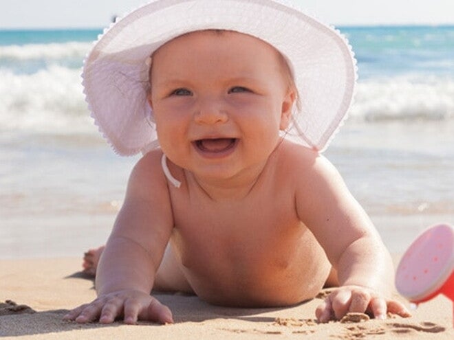 bebe en chapeau sur la plage