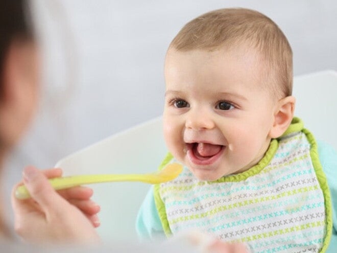 bébé de face qui ouvre la bouche face à une cuillère