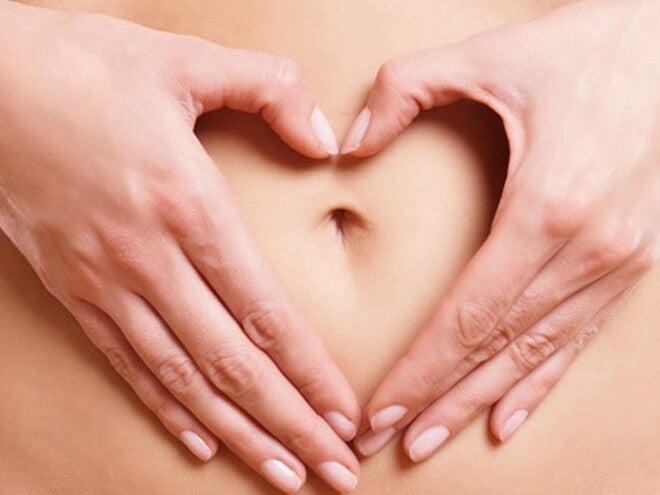 Ventre de femme avec mains en forme de cœur