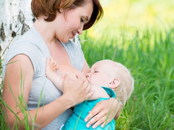 maman allaitant son bebe dans l'herbe maman allaitant son bebe dans l'herbe