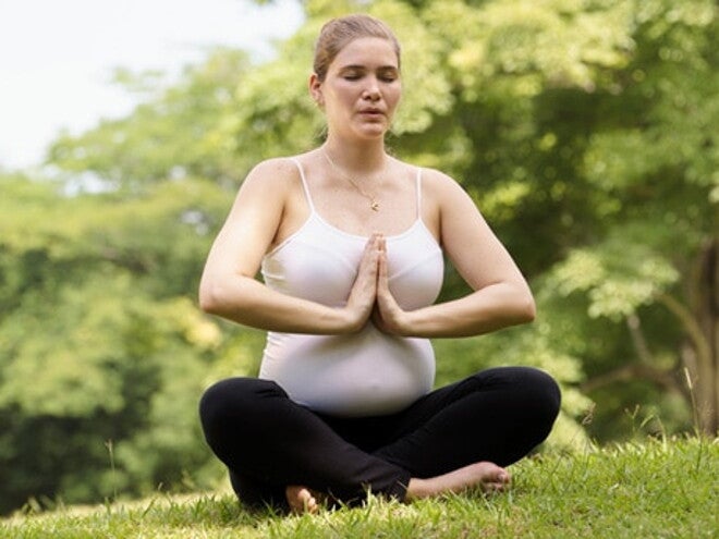 Femme en position de yoga dans l'herbe