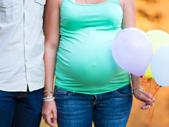Un homme et une femme enceinte avec des ballons dans la main