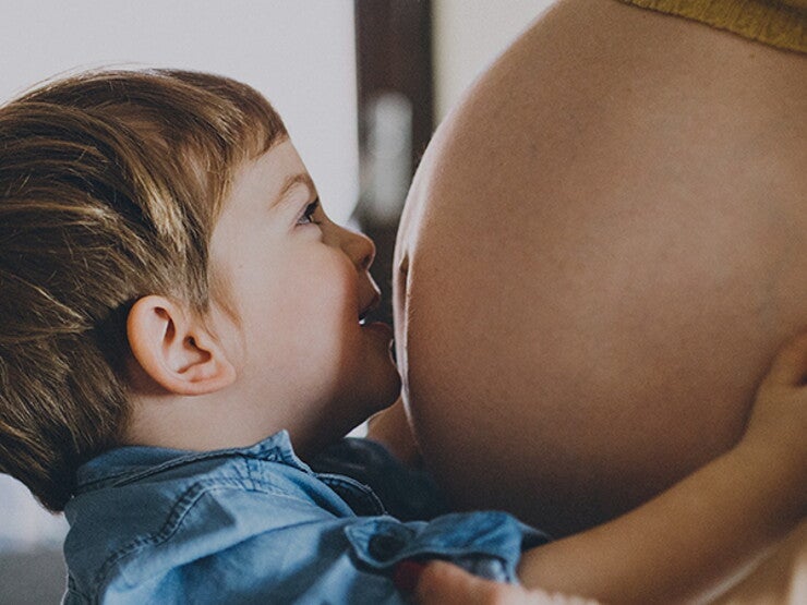 Toddler kisses mommy's belly